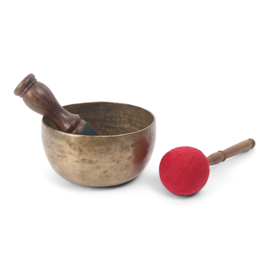 Bronze singing bowl with wooden handle and red mallet on a white background