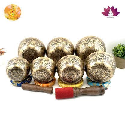 Set of bronze singing bowls with OM symbols on a white background