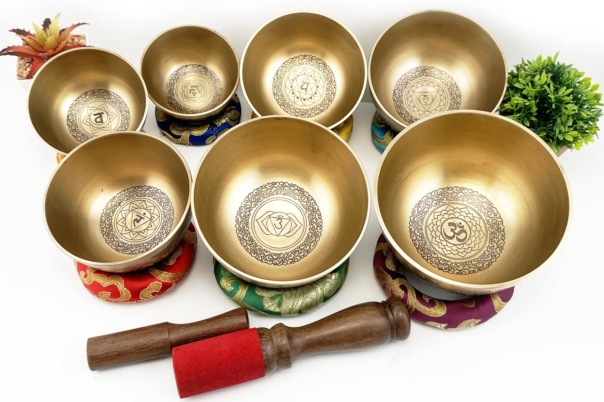 Set of gold singing bowls with a wooden mallet on a white background