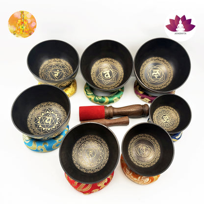 Set of black singing bowls with gold designs on a white background, featuring Ananta brand logo.