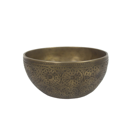 Decorative brass bowl with intricate patterns on a white background