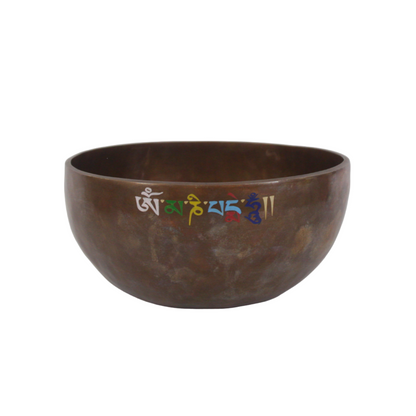 Brown singing bowl with engraved symbols on a white background