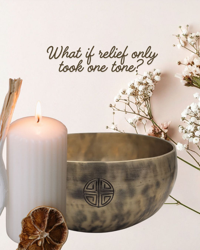 Tibetan singing bowl with a candle and flowers on a light background