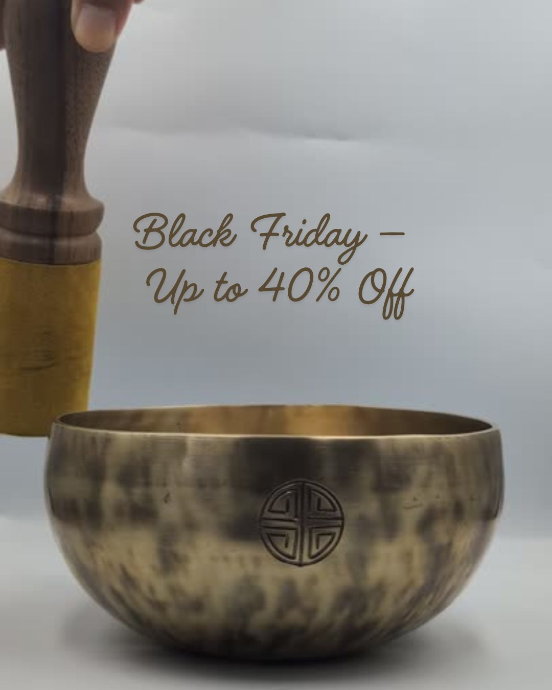 Bronze singing bowl with wooden mallet on a light gray background, featuring Black Friday sale text.