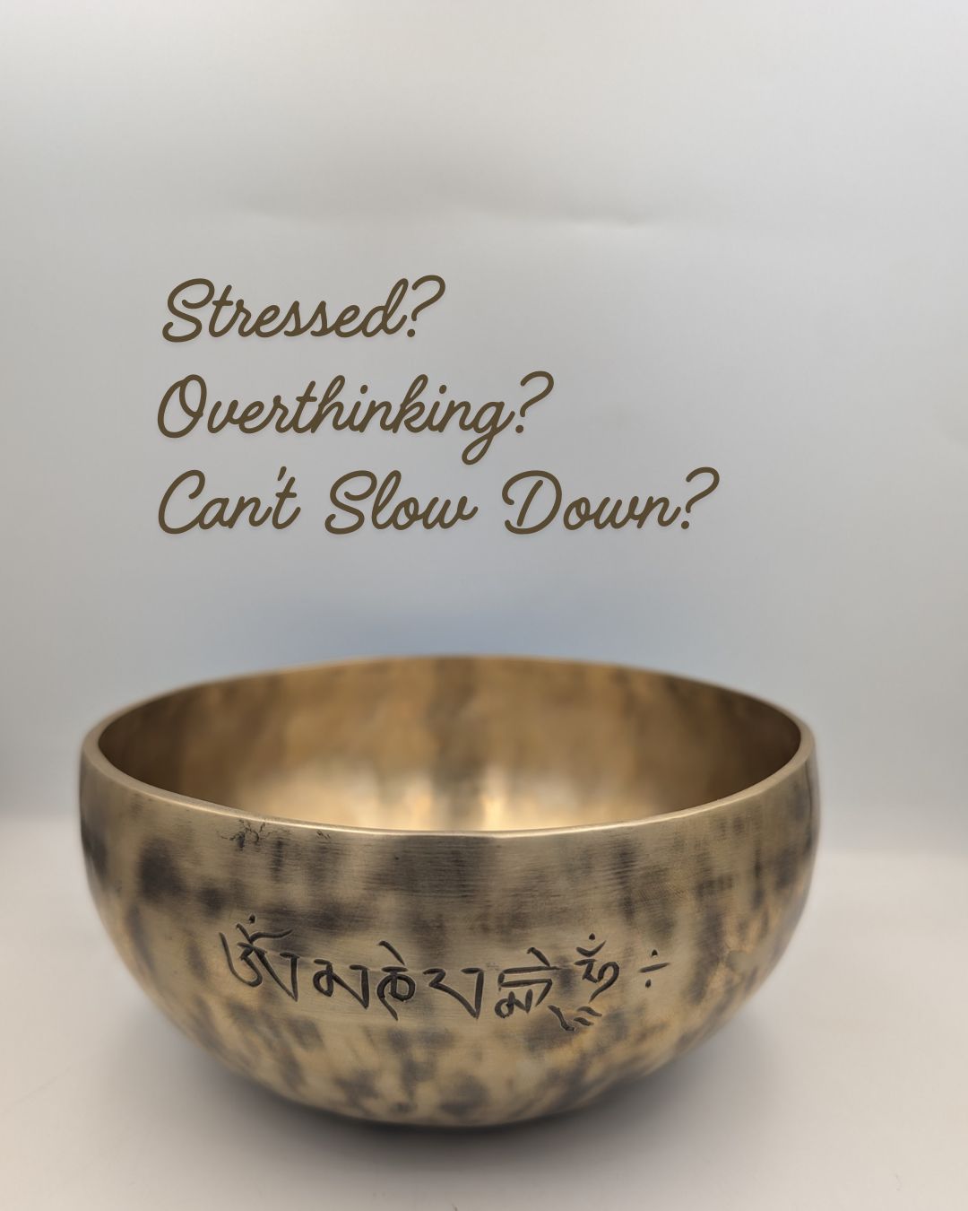 Bronze singing bowl with text on a light gray background