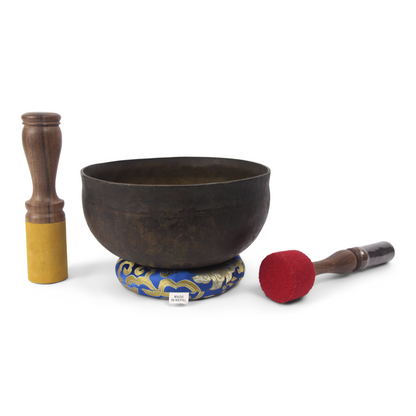 Tibetan singing bowl with accessories on a white background