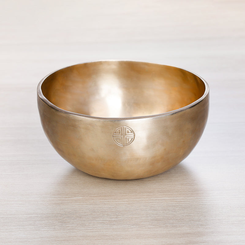 Full Moon Jhumkana singing bowl with smooth golden finish and laser-carved symbol on exterior — handcrafted in Nepal for meditation and sound healing