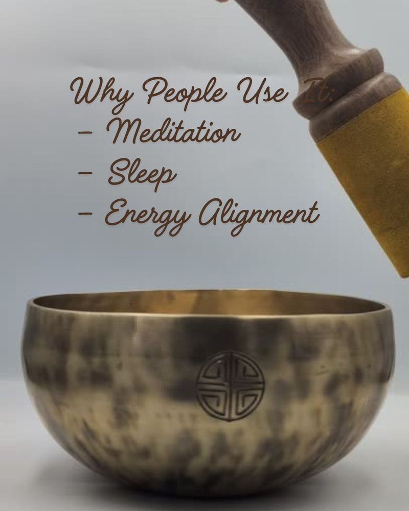 Tibetan singing bowl with wooden handle on a light gray background