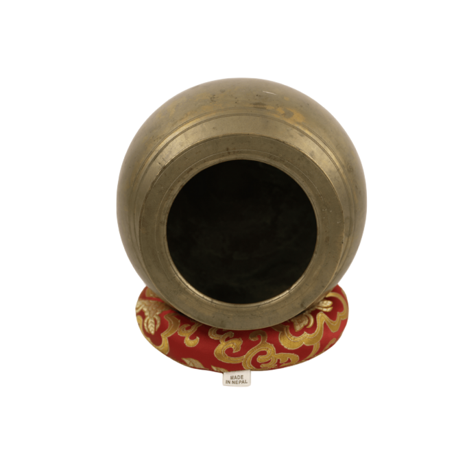 Brass pot with a red and gold decorative base on a white background
