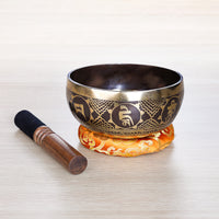 Laser carved singing bowl with Om Mani Padme Hum Tibetan script medallions and gold geometric etching on dark bronze finish — handcrafted in Nepal