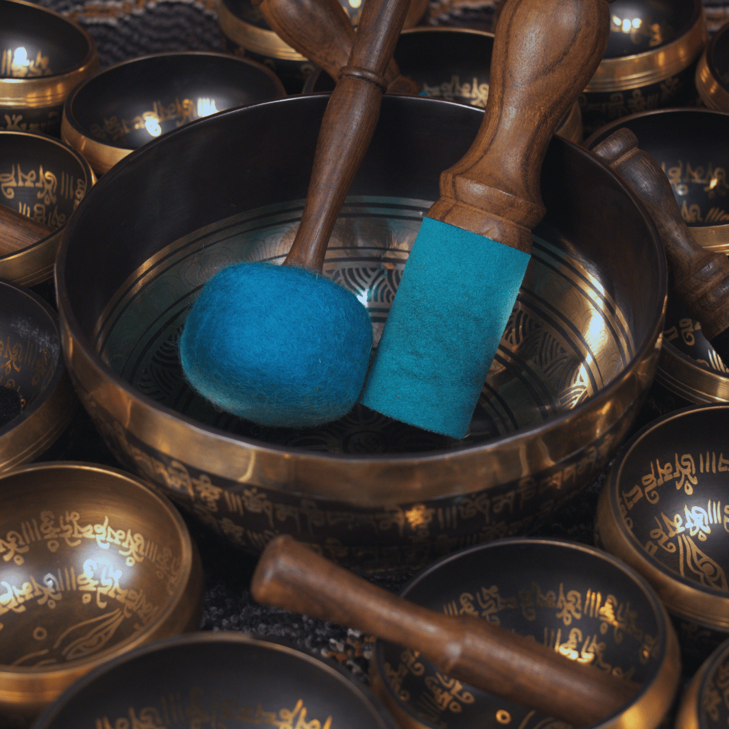 Tibetan singing bowls with wooden mallets and blue打击垫
