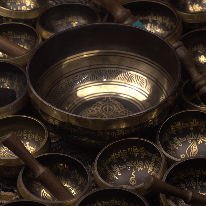 Collection of bronze singing bowls with engravings on a dark background