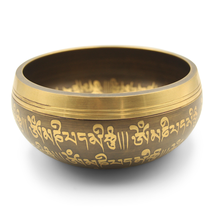 A bronze-colored Tibetan singing bowl with gold mantras and Buddha Eyes engraving on the exterior.