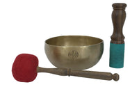 Brass singing bowl with wooden and red mallet on a white background