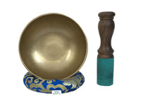 Brass singing bowl with wooden striker on a blue and gold decorative base