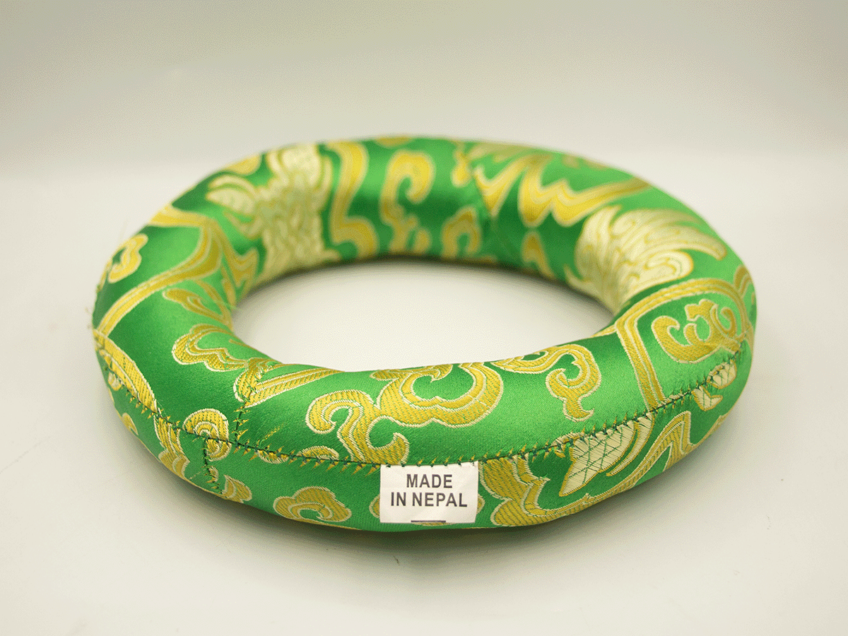 Green and gold decorative ring with 'Made in Nepal' label on a white background