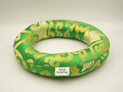 Green and gold decorative ring with 'Made in Nepal' label on a white background
