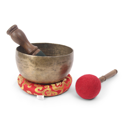 Tibetan singing bowl with wooden handle and red mallet on a white background