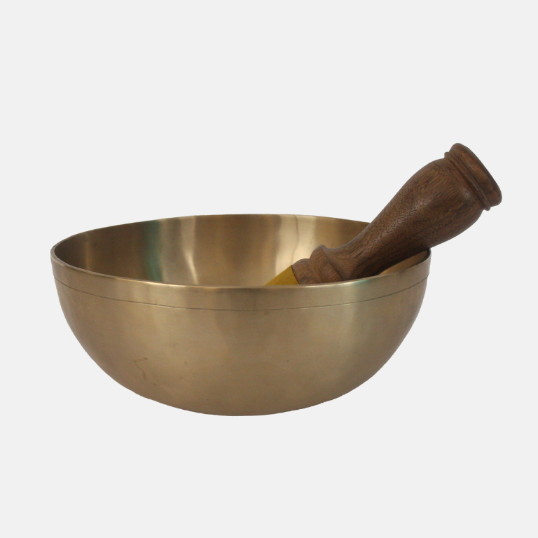 Brass bowl with wooden pestle on a white background